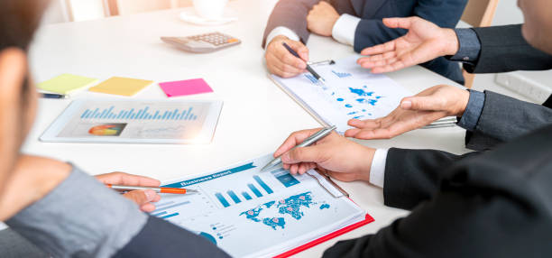 istock Group of businesspeople using graph chart and computer laptop, tablet discussing about business plan together in modern office. Business strategy. 1366231767