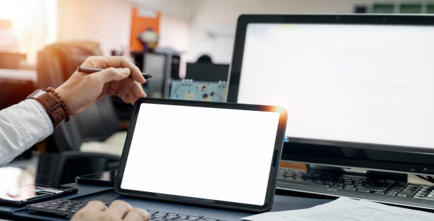 istock Business man working on digital tablet computer. Sitting at table in office, tablet horizontal screen mockup. 1366231823