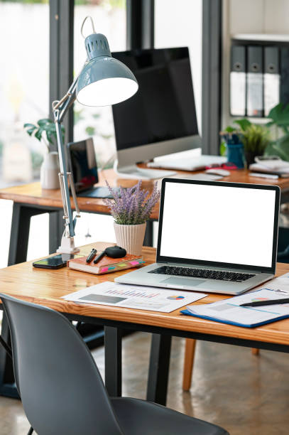 istock Mockup white screen portable tablet with magic keyboard on wooden table in co-workspace. 1366234065