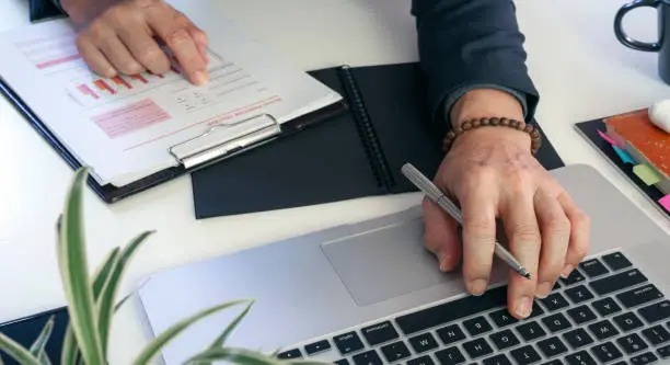 Photo of businessman working at office with his colleague at office, doing planning analyzing the financial report, business plan investment, finance analysis concept.