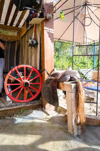 istock Red wooden wheel on a cart, saddle and ponytail 1366236100