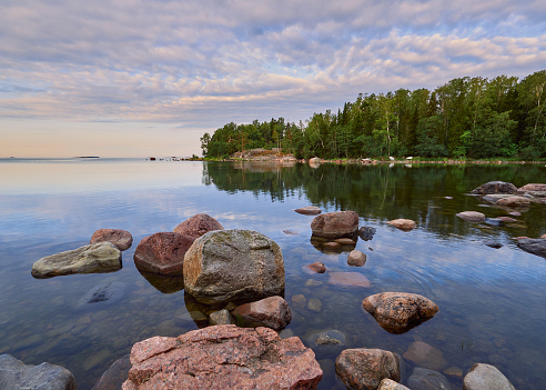 Summer walk along the Gulf of Finland on a wonderful calm morning in Lauttasaari next to the beautiful stones of Finnish nature.