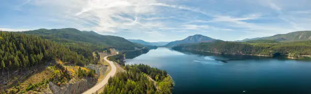 Aerial panoramic view of a scenic highway around mountains. East Kootenay, British Columbia, Canada.