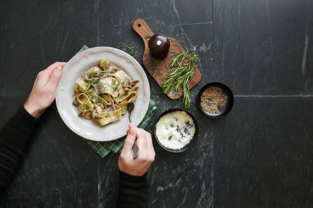 イタリアのビーフラグの煮込みをパッパルデッレで食べる男 - pappardelle ストックフォトと画像
