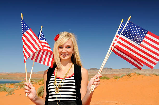 Young Woman Waving Several American Flags