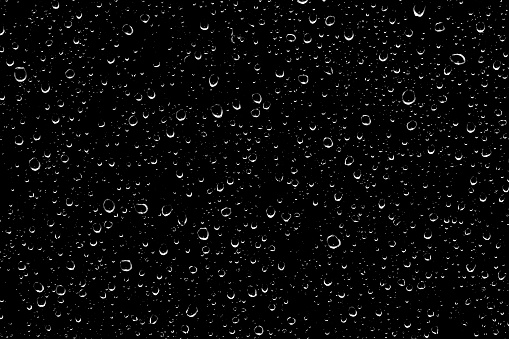 Water drops on glass transparent in black color.