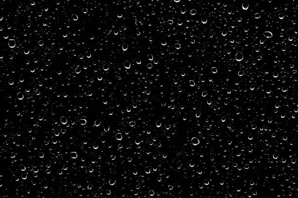 Water drops on glass transparent in black.