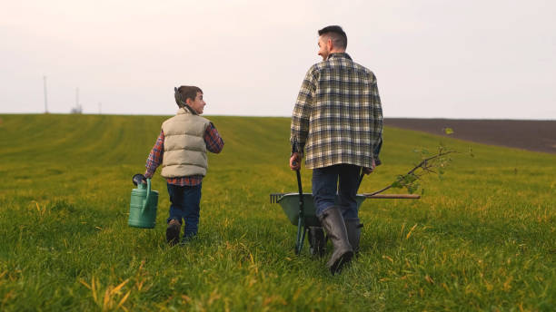 istock The farmer with his son walking through the field 1366241405