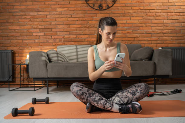istock Modern fit woman using smart phone 1366243897