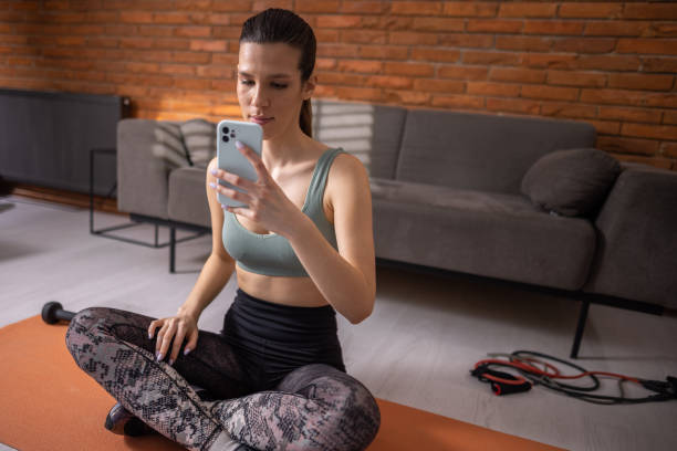 istock Beautiful fit woman using smart phone 1366244468