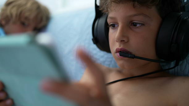 istock Kid playing video-game on tablet device. Boy touching screen plays online 1366247055