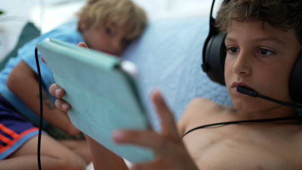 istock Kid playing video-game on tablet device. Boy touching screen plays online 1366247226