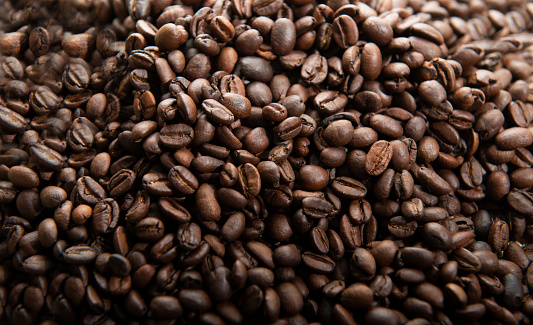 Dark fresh coffee beans , background. \nFreshly Roasted Coffee Beans.\nEmpty advertising space, studio detail shot high quality