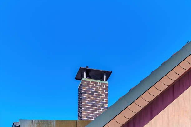 istock Roof with a chimney against a blue sky. 1366249370