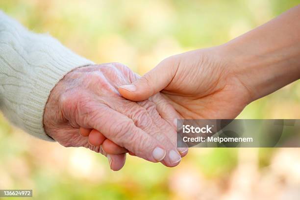 Senior And Young Holding Hands Stock Photo - Download Image Now - A Helping Hand, Adult, Adults Only