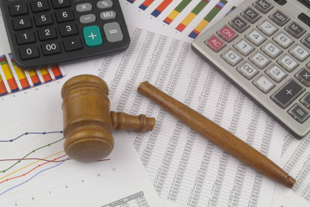 istock Broken judge gavel and calculators on financial documents. 1366250957