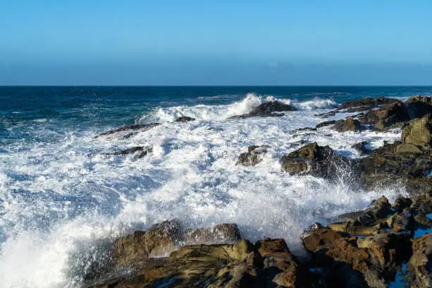 Betancuria, Las Palmas, Spain - December 10, 2021: Scenic view of tide with waves crashing on rocks of natural pools called "Aguas Verdes" (en. "Green Waters").