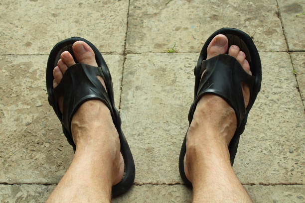weary legs wearing a sandal after a long jump across a pule on a sand dune in the Lut desert, the hottest desert in the world, also known as Kalut Desert