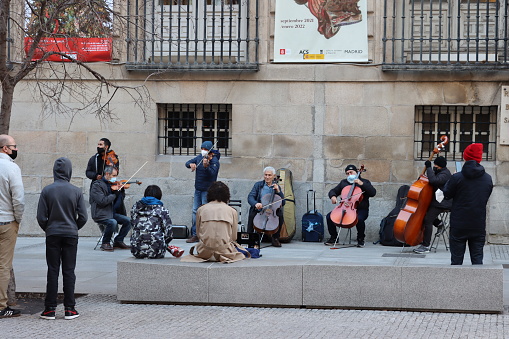 Madrid - Spain - January 7, 2022.\nA group of artists plays at the entrance of the Real Academia de Bellas Artes de San Fernando.