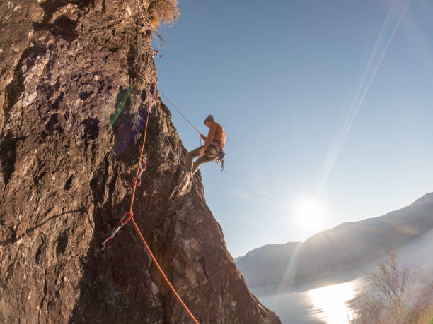 istock Mountain climber rappels on rock face 1366256247