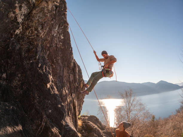 istock Mountain climber rappels on rock face, sunrise 1366256392