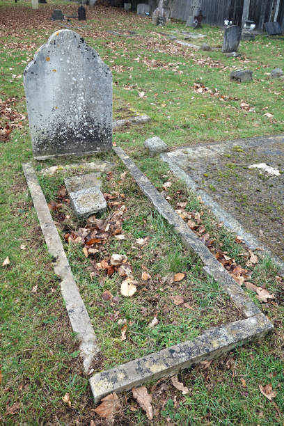 istock Old Graveyard with Broken and Fallen Crosses and Graves in Overgrown Grass Spooky 1366256912