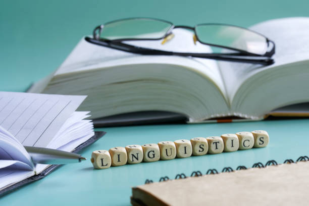 istock The word linguistics next to notepad, pen, open book and glasses. Concept for the study of liberal arts and linguistics at college and university. Pastel background. Selective focusing 1366260454
