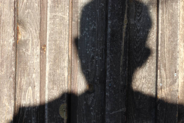 istock shadow of a man on a wooden wall 1366263202