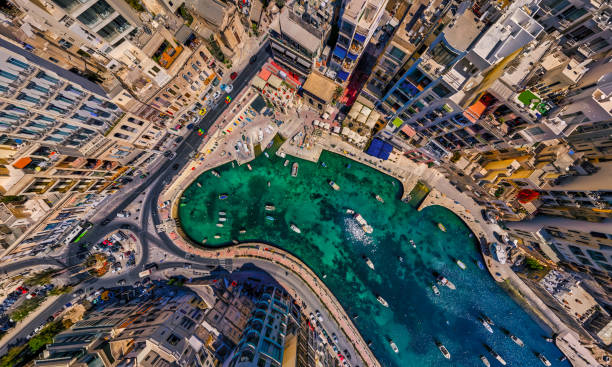 A bird's eye view Drone shot of Spinola Bay in St Julians, Malta A vibrant sea side village in Malta.  Home to the islands restaurants, bars and night life fishing village photos stock pictures, royalty-free photos & images