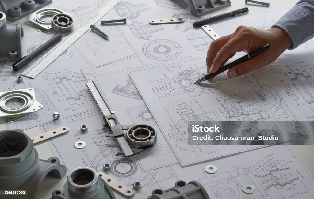 Engineer technician designing drawings mechanicalÂ parts engineering Engine
manufacturing factory Industry Industrial work project blueprints measuring bearings caliper tools Design Stock Photo