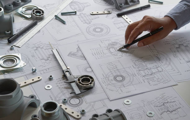 Engineer technician designing drawings mechanicalÂ parts engineering Engine
manufacturing factory Industry Industrial work project blueprints measuring bearings caliper tools stock photo