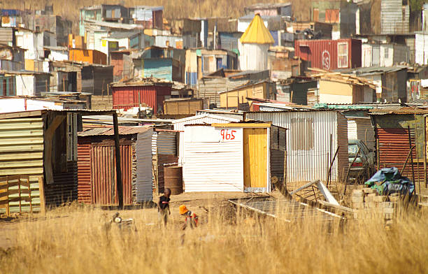 South African tin shack village A South African tin shack village near Johannesburg. The faces are blurred on the children in the foreground. segregation stock pictures, royalty-free photos & images