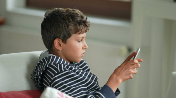 istock Little boy playing vide-game on portable console. Child plays game 1366270390