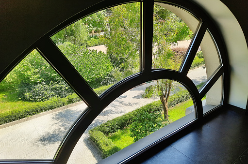 Unusual rounded window in the interior. The concept of a modern interior.
