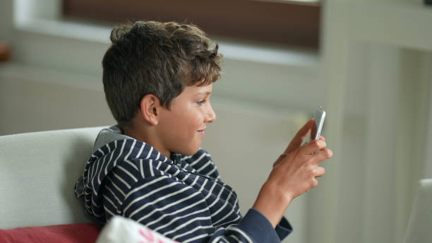 istock Little boy playing vide-game on portable console. Child plays game 1366270736