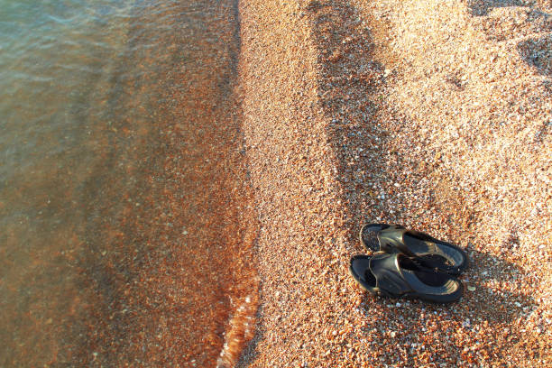 istock Black beach slippers on the seashore. Close-up. Background. Scenery. 1366271573