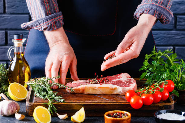 istock man cooking beefsteak on a kitchen, close-up 1366272736