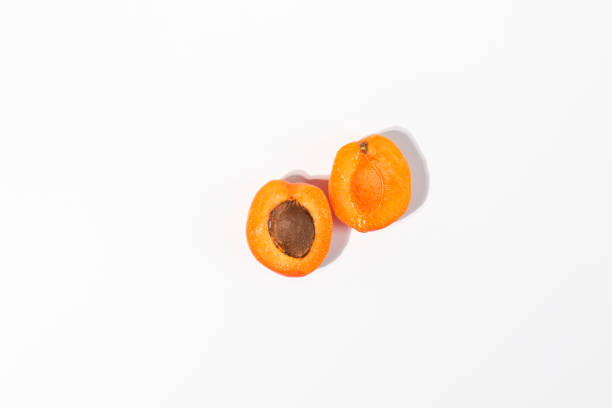 Fresh apricot halves on white background