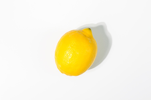 Ripe yellow lemon citrus fruit on white background