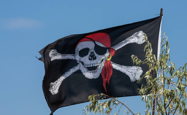 istock A skull and cross bones pirate flag waving in the wind 1366277747