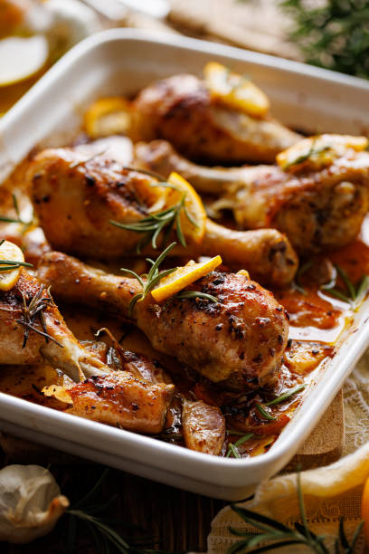 istock Roasted chicken legs drumsticks with rosemary, garlic and lemon in a ceramic baking dish 1366278709