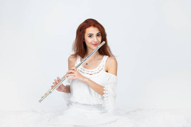 Female musician playing the flute.Young woman with flute. Female musician with her instrument.Looking at camera.