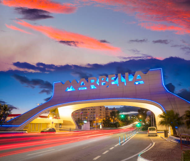 istock Marbella arch welcome sign at sunset with traffic light beams in 1366281809