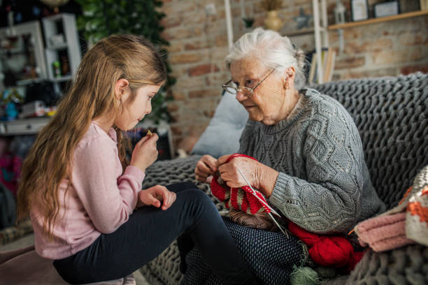 istock Granny teach granddaughter knitting with needles 1366283757