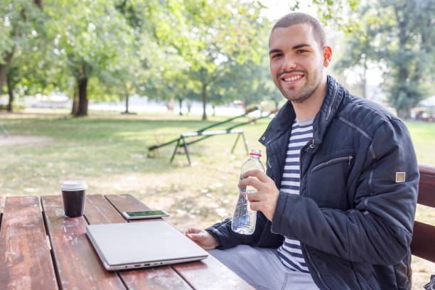 istock Young man freelancing from the park 1366284557