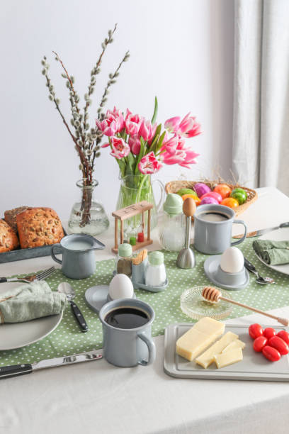 istock Easter Sunday brunch breakfast table setting with coffee, cheese, eggs and tulips 1366287884