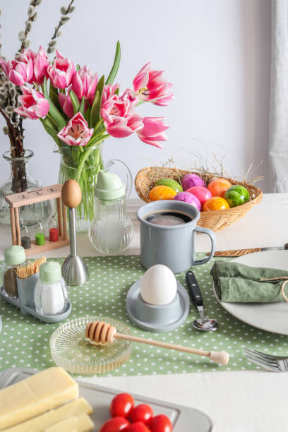 istock Easter Sunday brunch breakfast table setting with coffee, cheese, eggs and tulips 1366287912