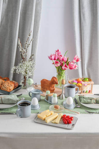 istock Easter Sunday brunch breakfast table setting with coffee, Easter lamb cake and tulips 1366287932