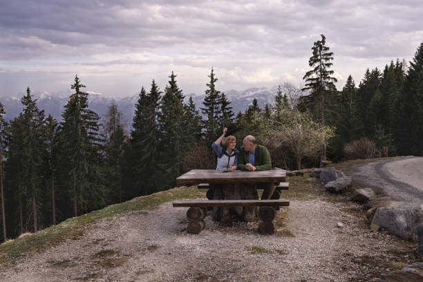 ペアは湖のほとりのベンチに座って、電話で話します - bench mountain park sitting ストックフォトと画像