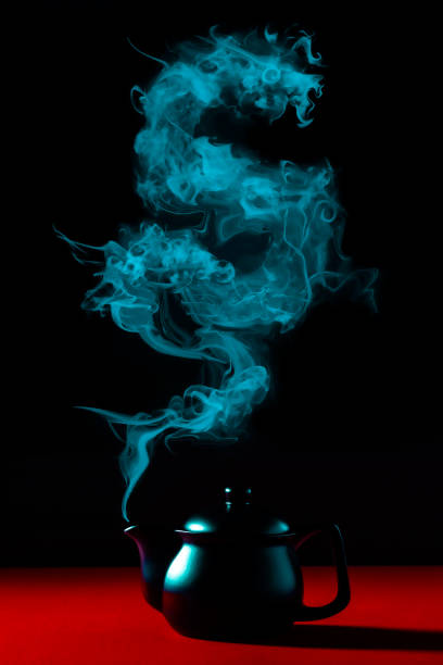 Chinese New Year magic composition on classy red table and elegant black teapot steaming a dragon silhouette.